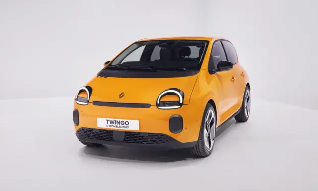 Renault elettrica piccola color arancio brillante, con fari rotondi e scritta "Twingo E-Tech Electric" sul frontale.