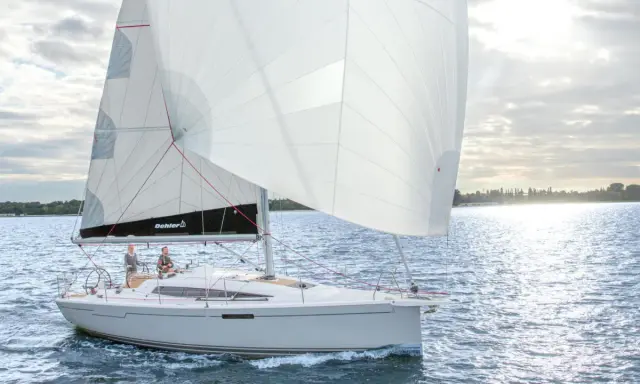 Voilier Dehler 34 naviguant par temps calme. Les voiles blanches sont gonflées, deux personnes sont à la barre. Fiche technique du bateau.