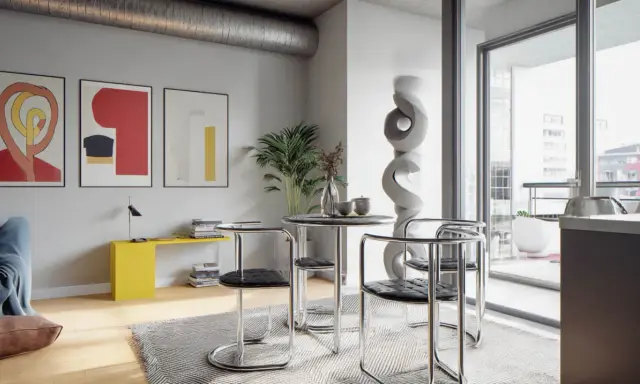 Nowoczesne wnętrze w stylu bauhaus z okrągłym stołem, krzesłami z chromowanej rury i abstrakcyjnymi obrazami na ścianie.