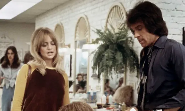 Goldie Hawn och Warren Beatty i en scen från en film. Hon har blont hår och en gul och brun tröja. Han har mörkt hår och en mörk skjorta.