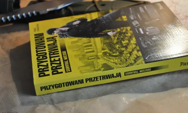 Książka "Przygotowani przetrwają. Survival miejski" leży obok noża. Podręcznik do przetrwania w miejskiej dżungli.