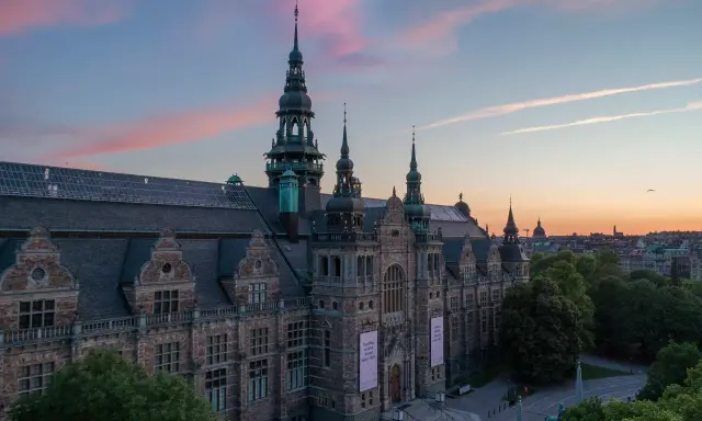 Nordiska museet badar i solnedgångens rosa sken.