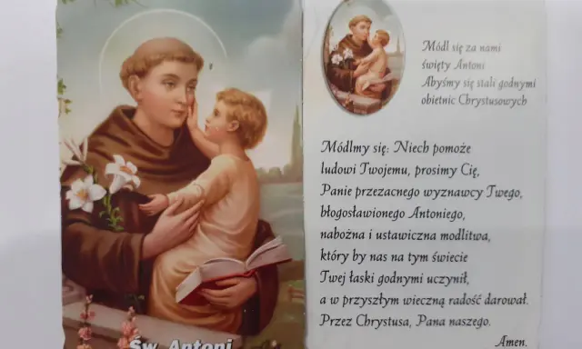 Święty Antoni z Dzieciątkiem Jezus, otoczony kwiatami lilii. Obok tekst modlitwy do świętego Antoniego.