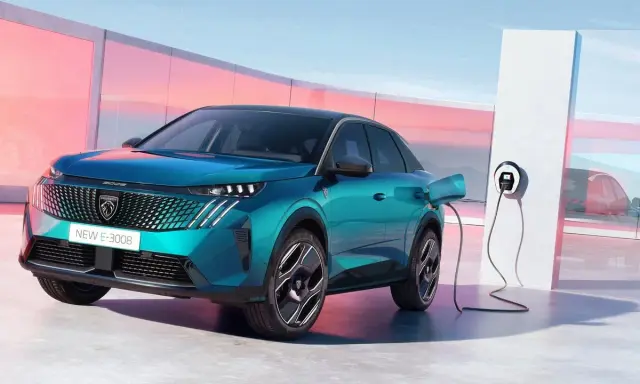 Un nuevo Peugeot E-3008 eléctrico enchufable, de color azul turquesa, cargando en un moderno punto de recarga.