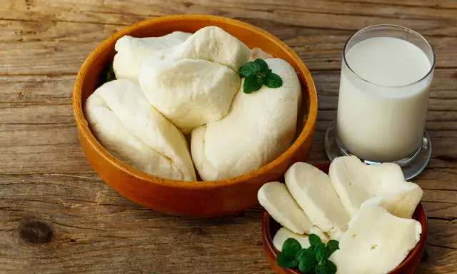 Ser halloumi w misce i na talerzyku, obok szklanka mleka. Czy ser halloumi jest zdrowy? To pytanie zadaje sobie wielu miłośników tego sera.
