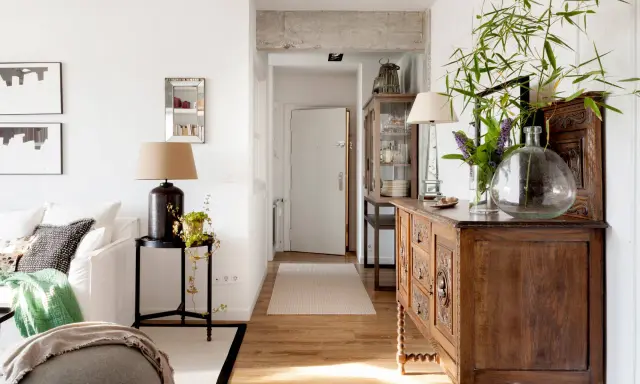 Un mueble oscuro puede alegrar una habitación con luz natural y plantas.