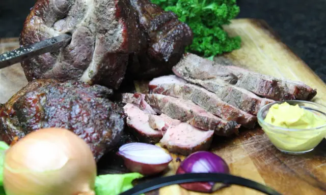 Saftiger Mutzbraten, frisch aufgeschnitten, mit Senf, Zwiebeln und Petersilie. Ein tolles Rezept für den Grill.