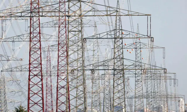 Hohe Strommasten, die Stromleitungen tragen, symbolisieren den Strom-Import und -Export Deutschlands.