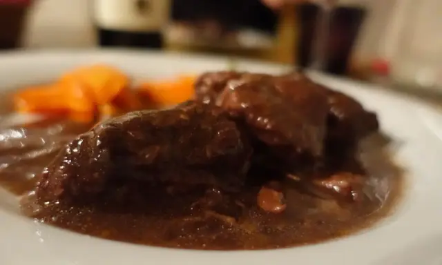 Un succulento brasato al barolo, tenero e saporito, accompagnato da carote arancioni.