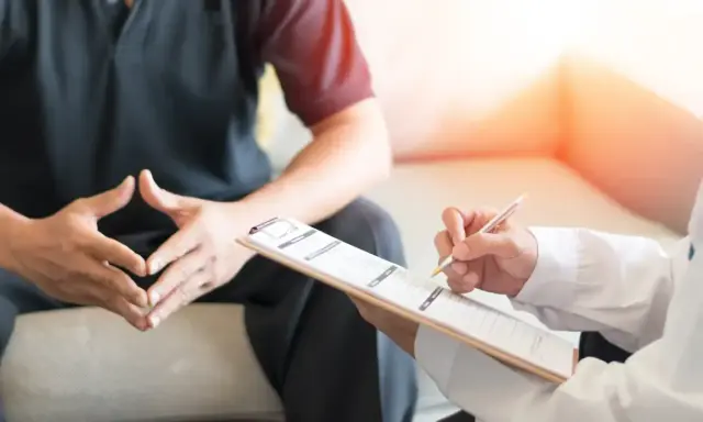 Lekarz notuje objawy pacjenta, który martwi się o swoją męską prostatę.