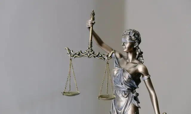 Figurka Temidy z wagą, symbol sprawiedliwości. Jej postawa sugeruje, że rozważa ona czynności przekraczające zwykły zarząd, szukając równowagi.