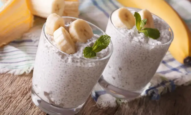 Dwa pucharki z puddingiem z nasion chia i bananem, idealne dla kobiet w ciąży. Zdrowe i pyszne!