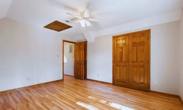 Habitación con suelo de madera clara y puertas de madera oscura, creando un contraste cálido.