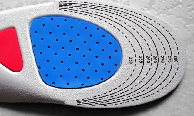 Semelle orthopédique personnalisée, une ordonnance podologue pour un confort optimal. La semelle présente une zone bleue perforée et des repères de taille.