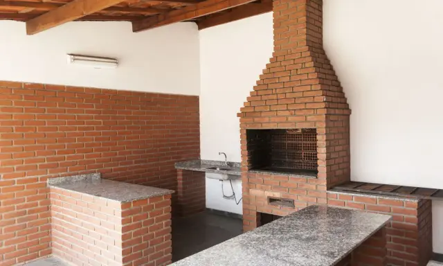 Solidny grill murowany z cegły, projekt z blatem i zlewem. Idealny na rodzinne spotkania.