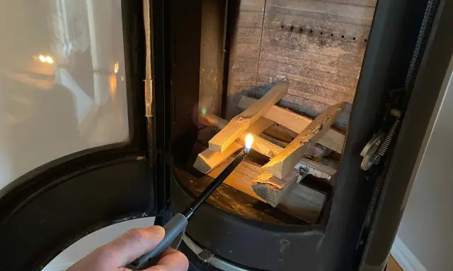 Tända en brasa i kaminen med tändare. Viktigt med brandskydd kamin för säkerhet.