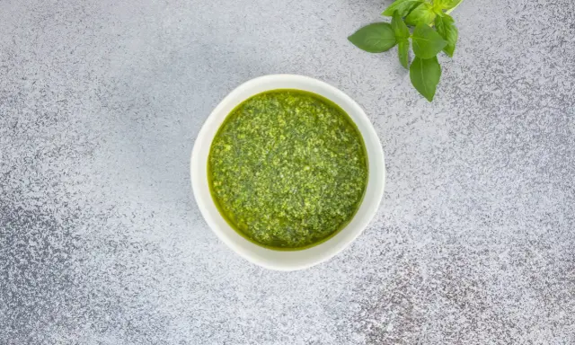 Frisches Basilikum und ein Schälchen mit selbstgemachtem Pesto. Ein einfaches Pesto Rezept für Pasta.
