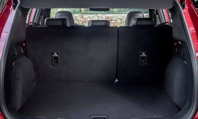 Maletero del Ford Kuga con asientos abatidos, listo para cargar equipaje o compras. Se aprecian los anclajes ISOFIX.