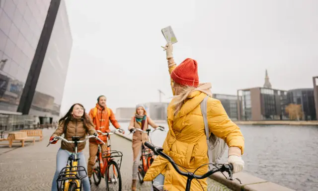 Amici esplorano Copenaghen in bicicletta, godendosi la libertà di muoversi con le biciclette gratis.