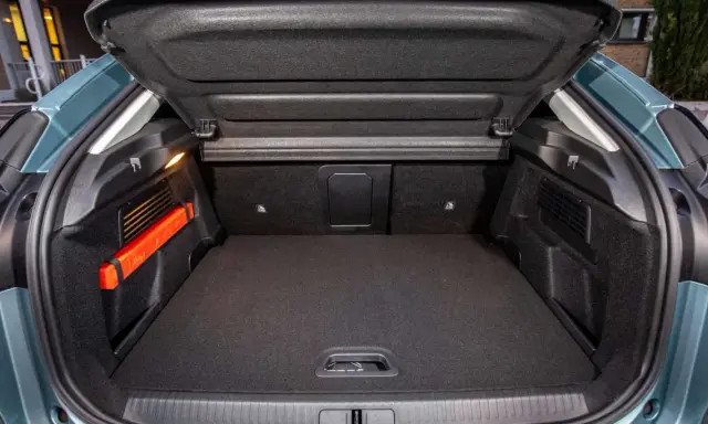 Maletero Citroën C4 vacío, con el triángulo de emergencia naranja visible a la izquierda. Espacio de carga listo para tus aventuras.