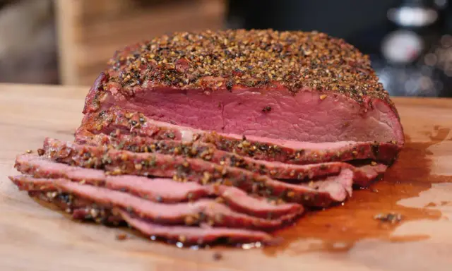 Perfekt gegrilltes Roastbeef mit kräftiger Gewürzkruste, saftig rosa geschnitten auf einem Holzbrett. Ein Genuss für jeden Grillmeister!