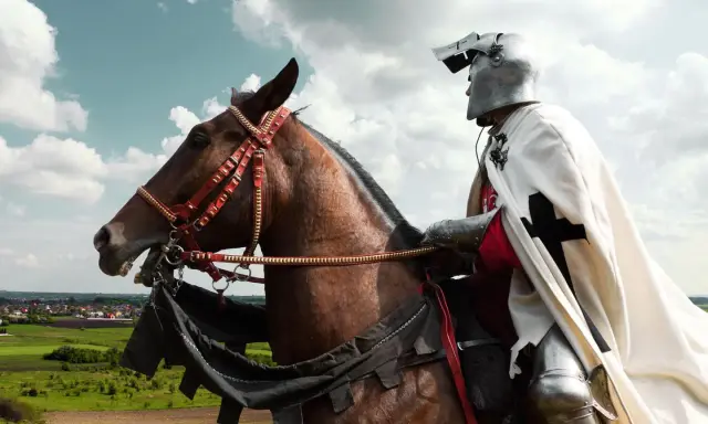 Ein Ritter in voller Rüstung reitet auf einem braunen Pferd. Die Szene erinnert an Geschichten für ritter kinder.