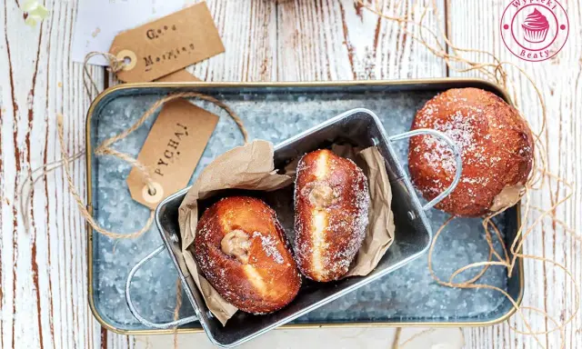 Pączki z pysznym kremem czekoladowym, posypane cukrem. Idealne na słodkie śniadanie.