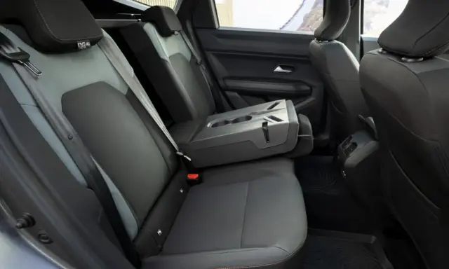 Interni Dacia Bigster: sedili posteriori in tessuto grigio e nero, bracciolo centrale ribaltabile con portabicchieri.