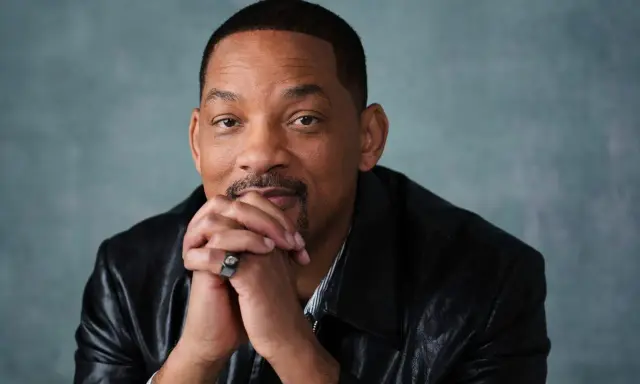 Will Smith, känd från många filmer och tv-program, sitter med händerna knäppta framför sig.