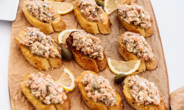 Bruschettas garnies de rillettes de sardines, câpres et quartiers de citron. Un délice pour l'apéritif.
