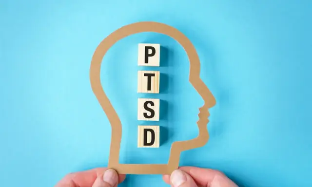 Klocki z literami P, T, S, D układają się w napis PTSD wewnątrz sylwetki głowy. Zrozumienie, ptsd co to, jest kluczowe dla pomocy.