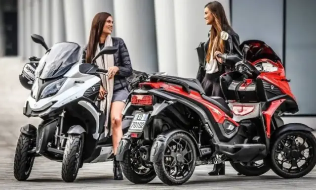 Dos mujeres posan junto a dos motos de cuatro ruedas, ideales para quienes tienen carnet B y buscan una experiencia de conducción diferente.