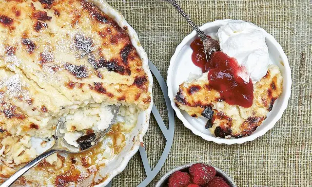 En gyllene falsk ostkaka med krispiga kanter, serverad med vispad grädde, sylt och färska hallon.