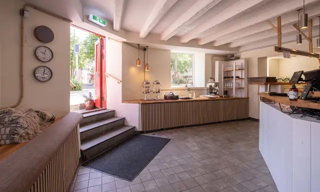 Välkomnande entré till ett café med trädetaljer och en disk. Perfekt för att läsa sukki-ne recensioner.