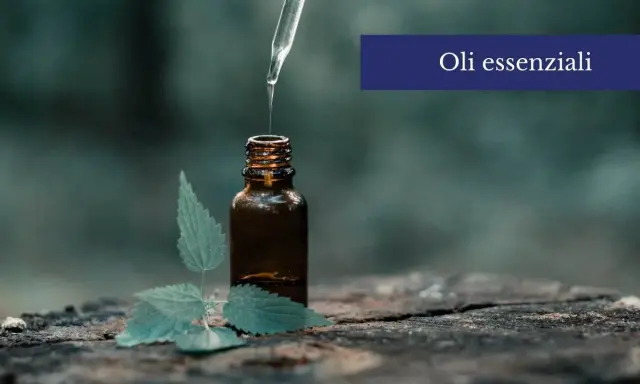 Una goccia di olio essenziale cade da un contagocce in una bottiglia ambrata, accanto a una foglia verde. Scopri come usare gli oli essenziali sulla pelle per un benessere naturale.