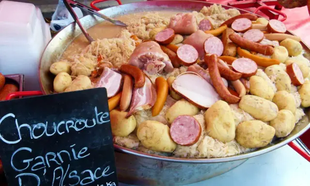 Choucroute garnie d'Alsace, une spécialité alsacienne généreuse avec saucisses, lard, porc et pommes de terre sur choucroute.