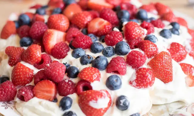 En härlig pavlova med vispgrädde och massor av färska bär. Ett perfekt pavlova recept för sommaren!