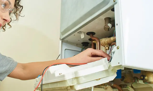 Technicienne vérifiant une pompe à chaleur qui ne chauffe pas quand il fait froid.