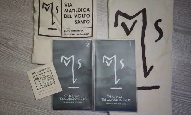 Kit per il pellegrino: sacca, credenziale e due carte dell'escursionista per la Via Matildica del Volto Santo.