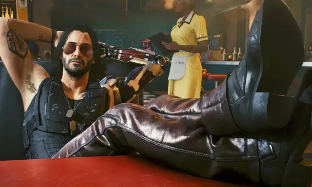 Un hombre con brazo cibernético y tatuajes, con las botas puestas sobre una mesa, como en una guía de Cyberpunk 2077.