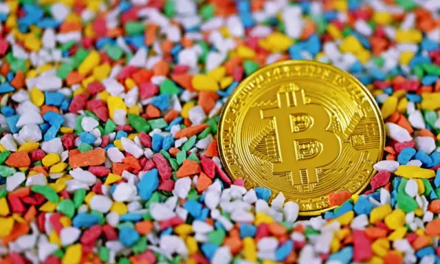 Złoty bitcoin wśród kolorowych kamyczków. Czy to symbol bogactwa, które James Howells stracił na zawsze?