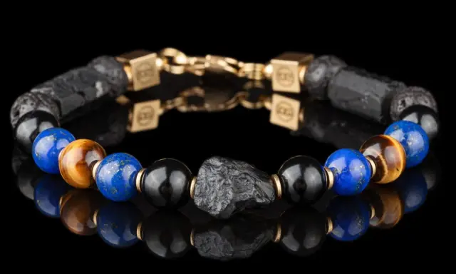 Bransoleta z lapis lazuli i kamienia wulkanicznego, ozdobiona złotymi elementami. Idealna dla osób szukających swojego znaku zodiaku.