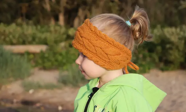 Niña con diadema de lana tejida, ideal para aprender como hacer diademas de lana para niñas.