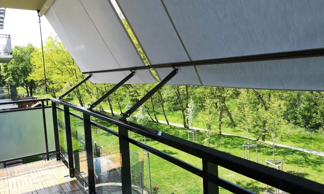 Nowy markiza to świetny sposób, jak osłonić balkon w bloku przed słońcem. Drewniana podłoga i szklane balustrady dodają uroku.