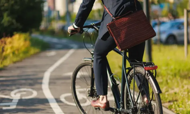 Biznesmen na rowerze, jadący ścieżką rowerową. Zastanawia się, ile promili na rowerze jest dopuszczalne, by bezpiecznie dotrzeć do celu.