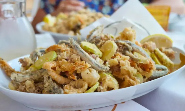 Fritto misto di pesce e verdure, un'ottima idea per cosa mangiare a Riccione. Croccante e saporito, perfetto con una caraffa di vino bianco.