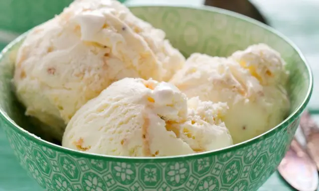 Kremowe lody z mascarpone w zielonej miseczce, idealne na upalny dzień.