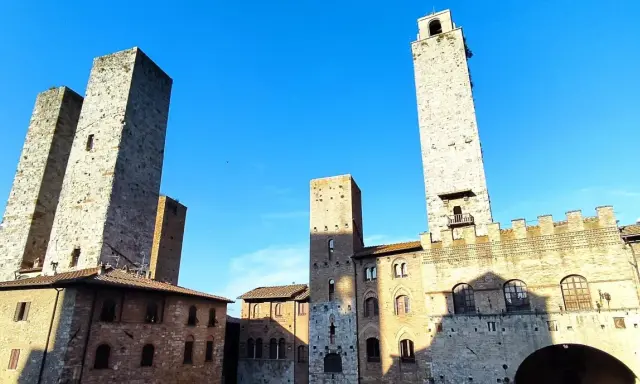 Wieże średniowiecznego miasta San Gimignano wznoszą się dumnie pod błękitnym niebem.