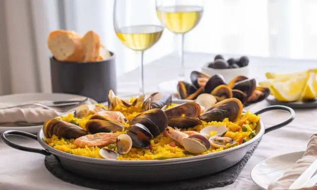 En härlig paella med skaldjur och ris, perfekt att avnjuta med ett glas vitt vin till paella. Serveras med citronklyftor och oliver.