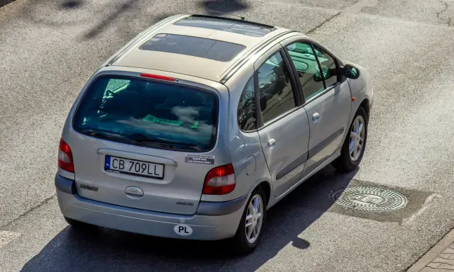 Srebrny Renault Scenic z naklejką "Ubezpieczony przez mafię". Szybkie auta i zimna noc, jak w tekstach SB MAFFIJA.